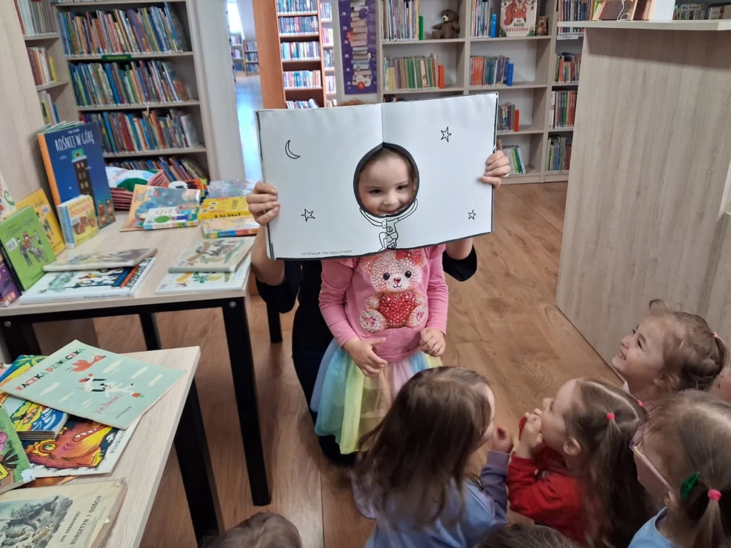 Przedszkolak prezentuje książkę podczas zajęć