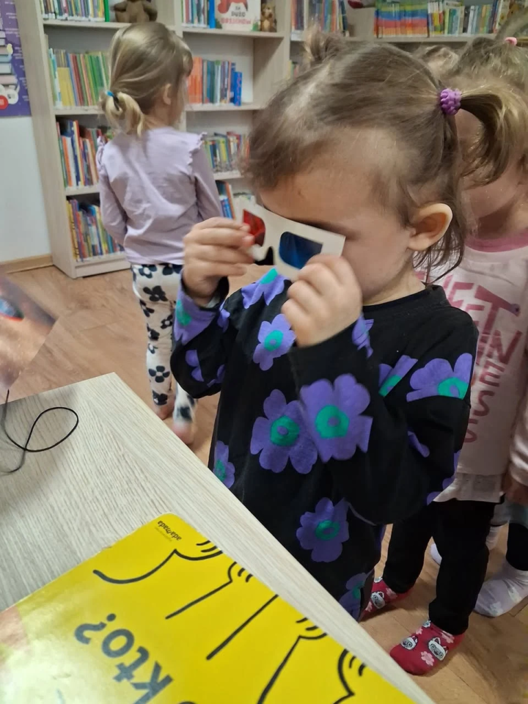 Dziewczynka ogląda książkę sensoryczną