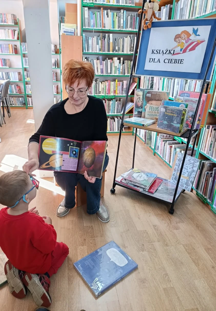 Bibliotekarka prezentuje dzieciom książkę